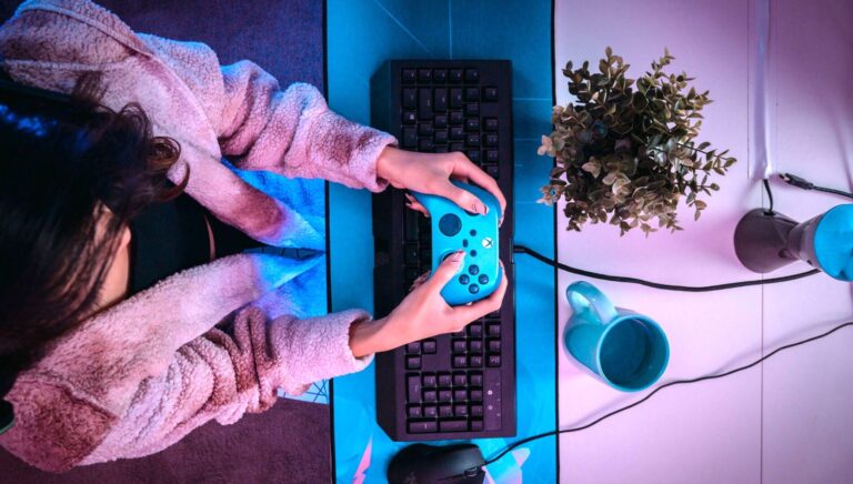 Overhead image of young woman playing a video game holding an Xbox game controller